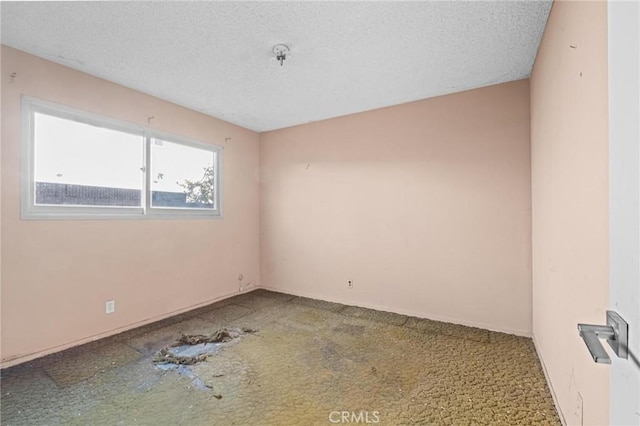 unfurnished room with a textured ceiling