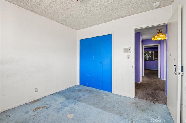 unfurnished bedroom featuring a textured ceiling and carpet flooring