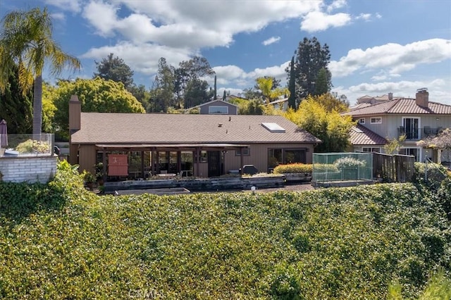 rear view of property featuring fence