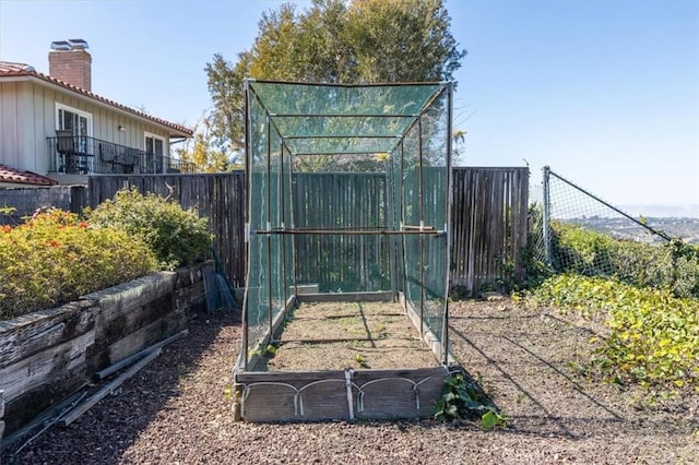 view of gate with fence and a garden