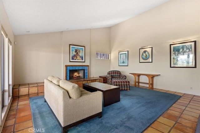 tiled living area with a tile fireplace and lofted ceiling