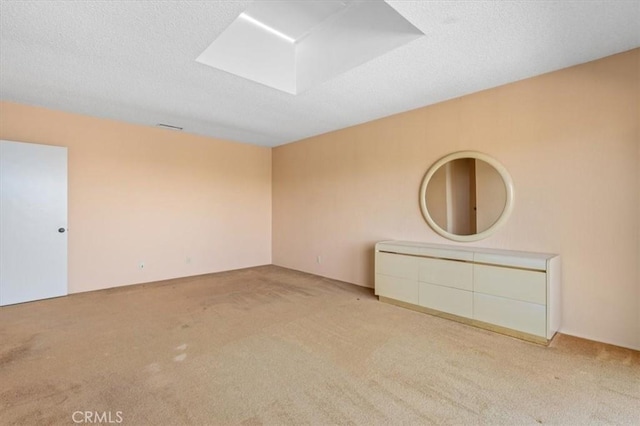 carpeted spare room with a textured ceiling