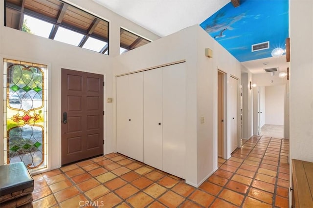 foyer with lofted ceiling and visible vents