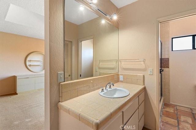 bathroom with backsplash, vanity, and an enclosed shower