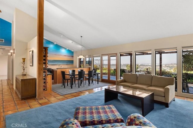 tiled living room featuring vaulted ceiling, french doors, carpet, and track lighting