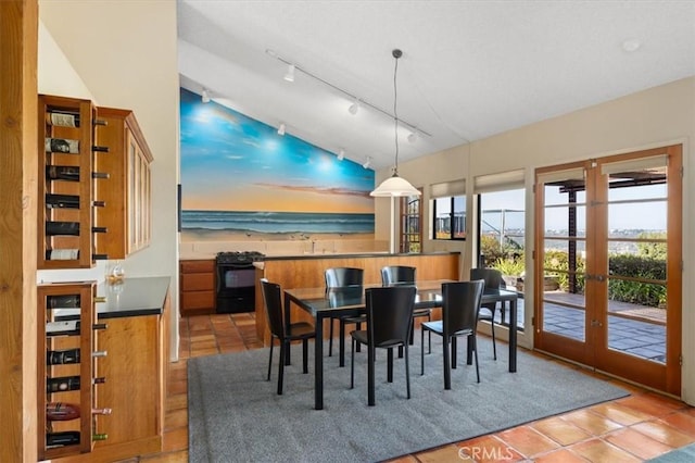 dining area with light tile patterned floors, vaulted ceiling, and french doors