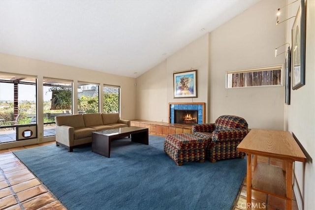 living area featuring lofted ceiling and a tile fireplace