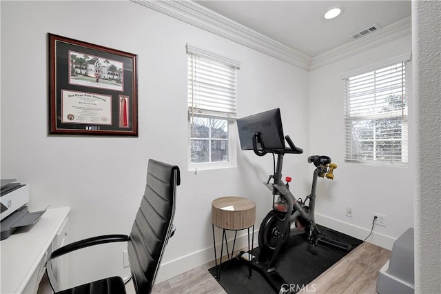 exercise room with baseboards, visible vents, crown molding, and wood finished floors