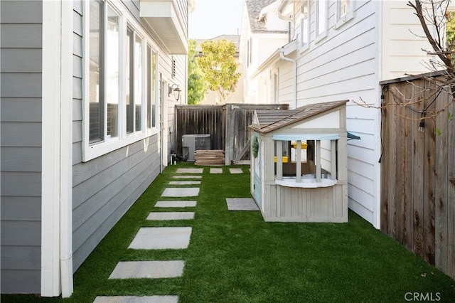 view of yard featuring central AC and fence
