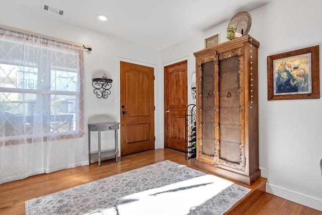 foyer featuring recessed lighting, wood finished floors, visible vents, and baseboards