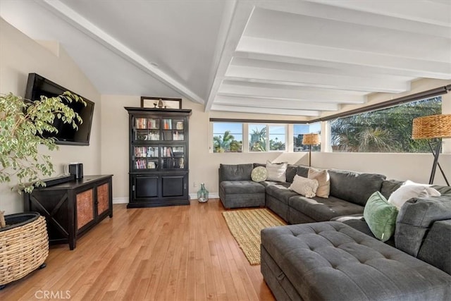 interior space with vaulted ceiling with beams, light wood-style flooring, and baseboards