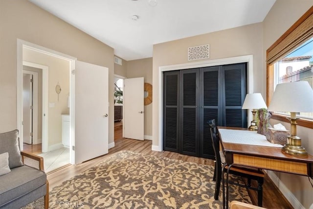 home office featuring visible vents, baseboards, and wood finished floors