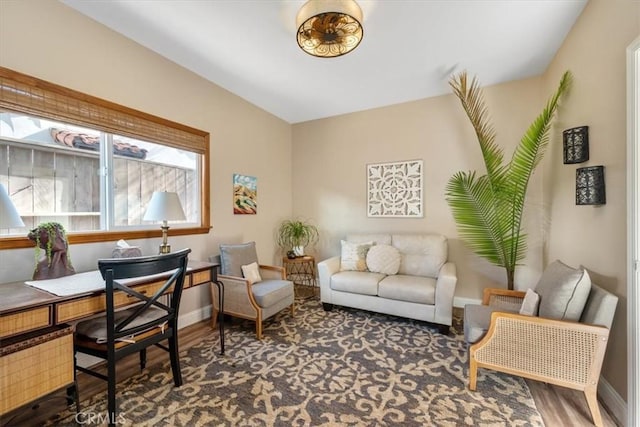 living area featuring baseboards and wood finished floors