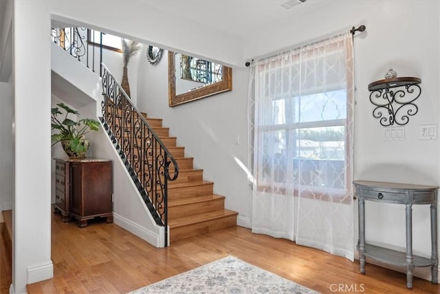 interior space with stairs, baseboards, and wood finished floors