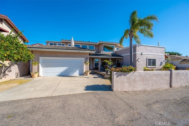 view of front of property featuring a garage, driveway, fence, and stucco siding