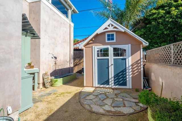 view of shed featuring fence