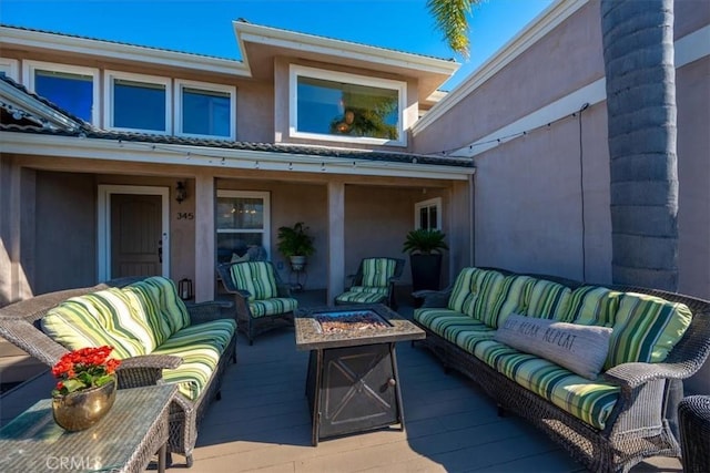 view of patio / terrace with a deck and an outdoor living space with a fire pit