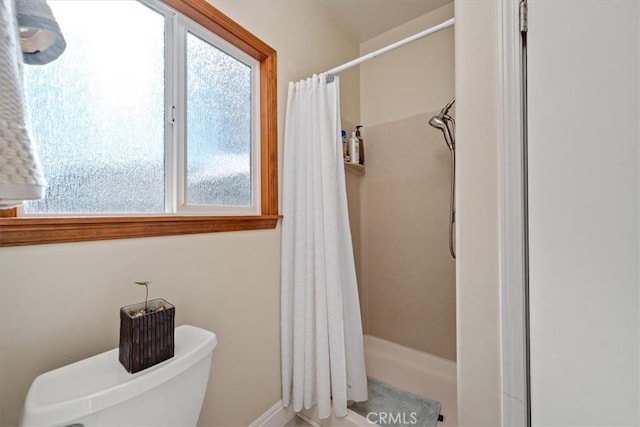 bathroom with curtained shower and toilet