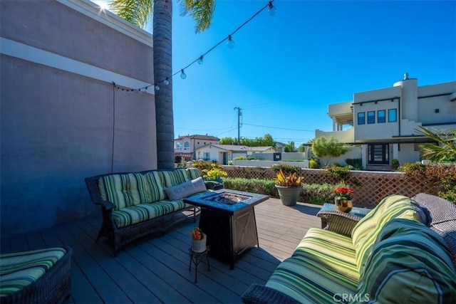 deck featuring an outdoor living space with a fire pit