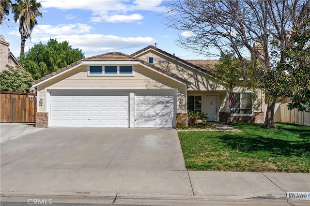 view of front of home featuring a front yard, brick siding, fence, and an attached garage