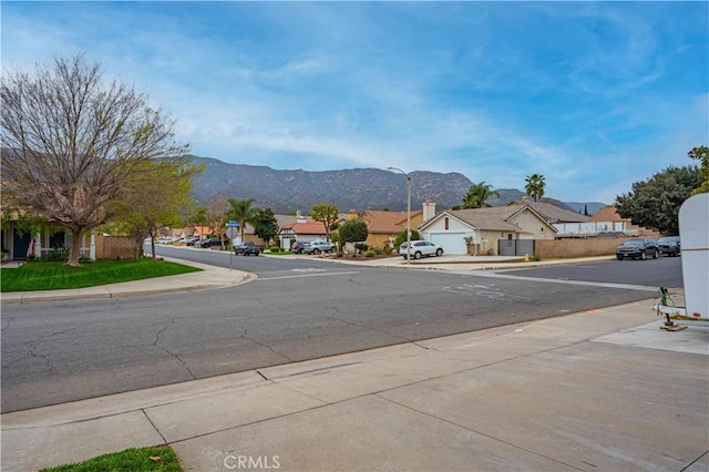 19390 Okeechobee Ln, Lake Elsinore, CA 92530 - view of asphalt street with a residential view, street lighting, sidewalks, and a mountain view