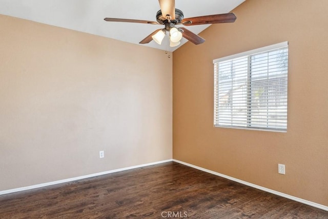 empty room featuring ceiling fan, dark wood-type flooring, and baseboards