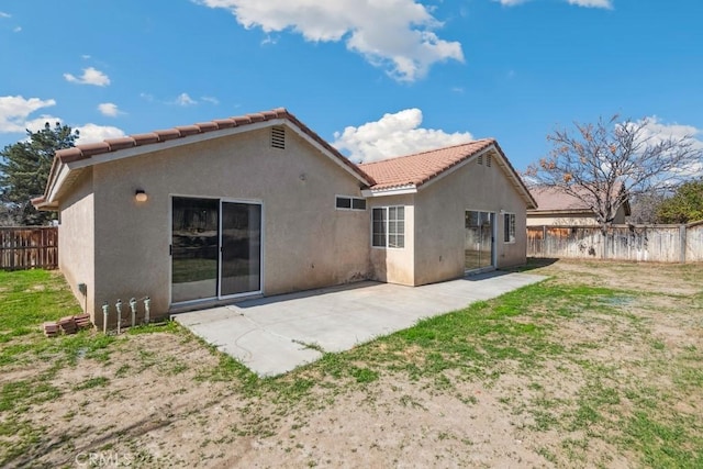 back of property with a patio area, fence, a tiled roof, and stucco siding