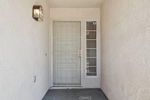 doorway to property featuring stucco siding