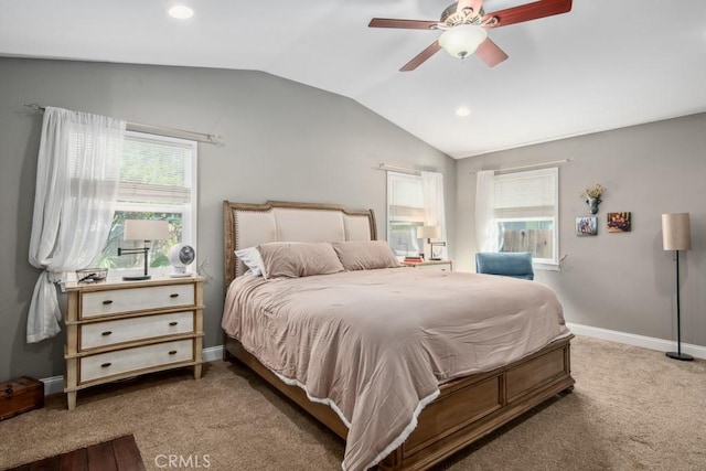 carpeted bedroom featuring lofted ceiling, multiple windows, a ceiling fan, and baseboards