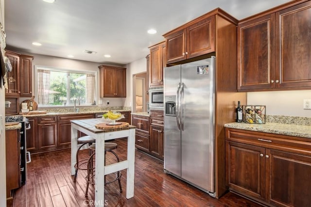 kitchen with appliances with stainless steel finishes, recessed lighting, dark wood-style flooring, and light stone counters