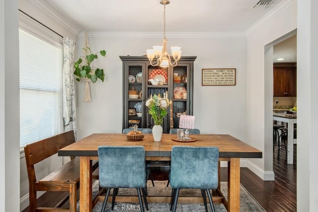 dining area with dark wood finished floors, a notable chandelier, visible vents, ornamental molding, and baseboards