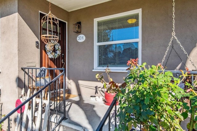 doorway to property featuring stucco siding