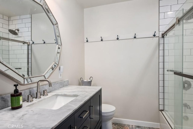 full bathroom featuring shower / bath combination with glass door, vanity, toilet, and baseboards