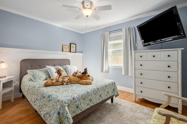 bedroom featuring ornamental molding, wood finished floors, a ceiling fan, and baseboards