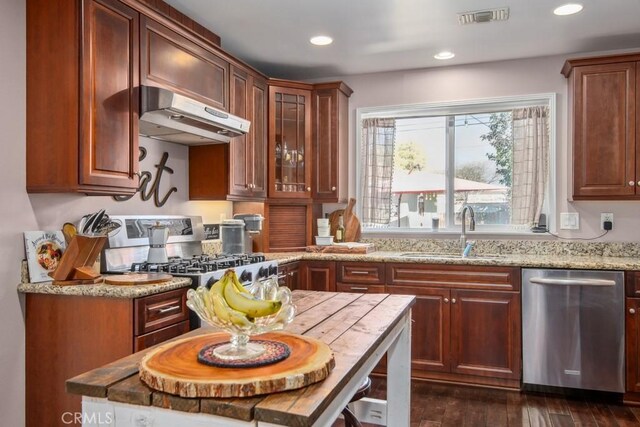 kitchen with dark wood-style flooring, stainless steel appliances, visible vents, a sink, and under cabinet range hood