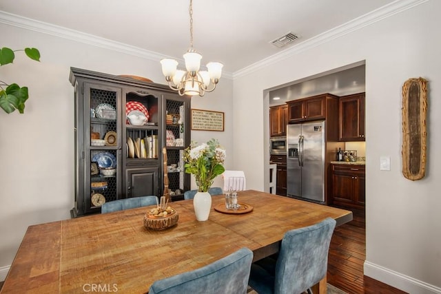 dining area with a notable chandelier, dark wood-type flooring, visible vents, baseboards, and crown molding