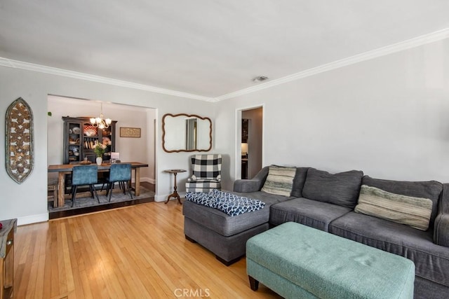 living area featuring crown molding, light wood-type flooring, a notable chandelier, and baseboards