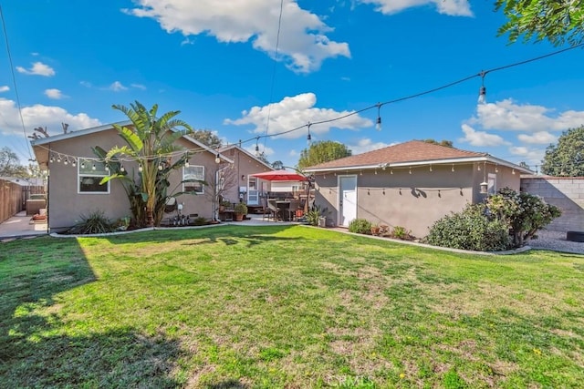 view of front of house featuring a front yard, fence, and stucco siding