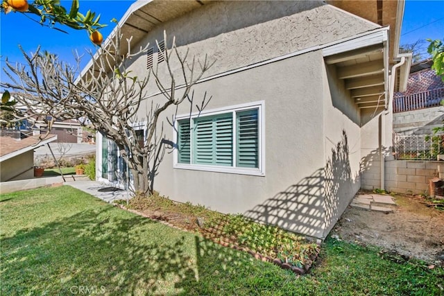 view of property exterior featuring a lawn and stucco siding