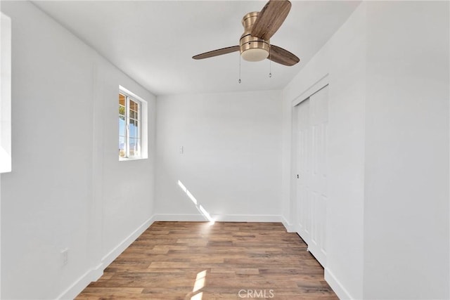 unfurnished room with ceiling fan, baseboards, and wood finished floors