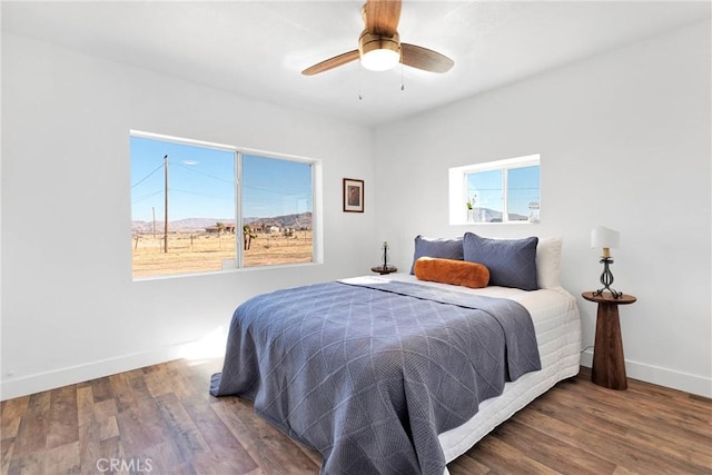 bedroom with wood finished floors, a ceiling fan, and baseboards