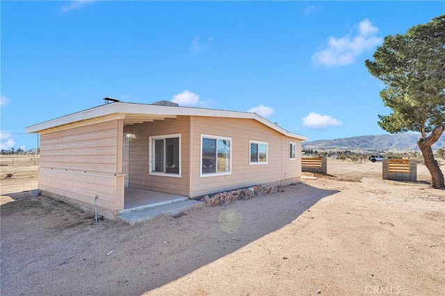 view of side of property with a patio area and a mountain view