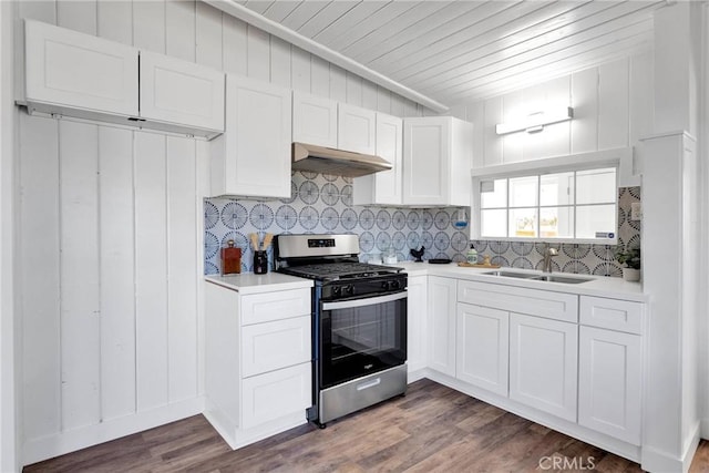 kitchen featuring decorative backsplash, dark wood finished floors, stainless steel range with gas stovetop, under cabinet range hood, and a sink