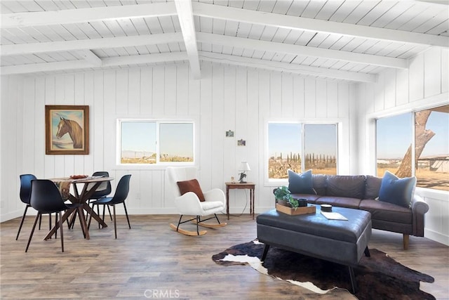 interior space with vaulted ceiling with beams, baseboards, and wood finished floors