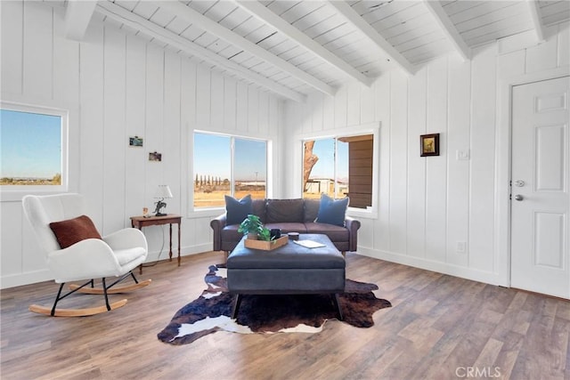 living room with vaulted ceiling with beams, wood finished floors, and baseboards