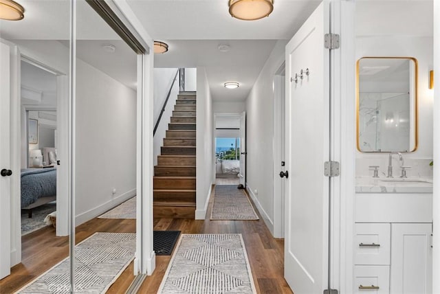 entrance foyer with stairs, wood finished floors, and baseboards