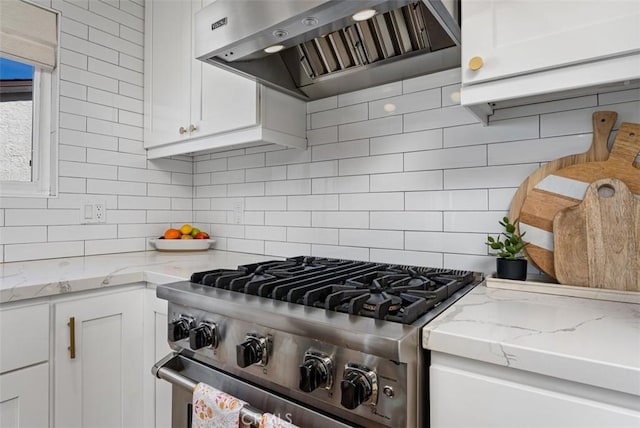 kitchen featuring white cabinets, tasteful backsplash, stainless steel stove, and range hood