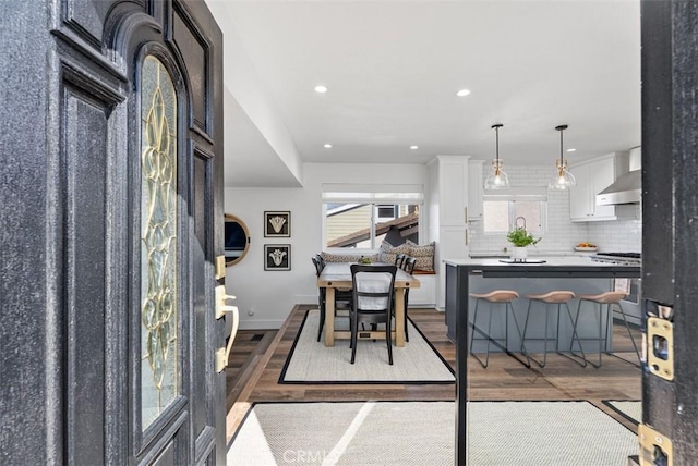 dining room featuring baseboards, wood finished floors, and recessed lighting