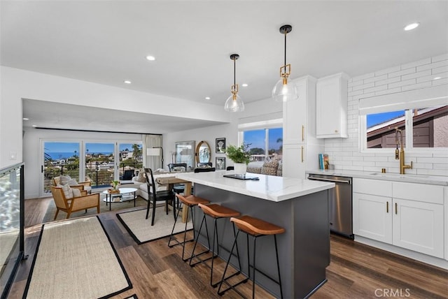 kitchen featuring a kitchen island, dark wood finished floors, and stainless steel dishwasher