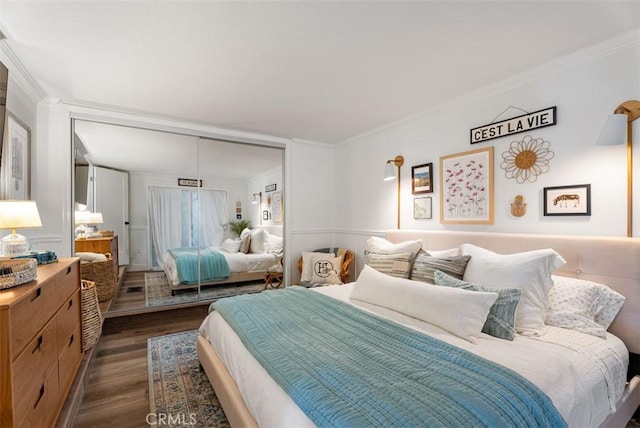 bedroom featuring ornamental molding, a closet, and dark wood finished floors